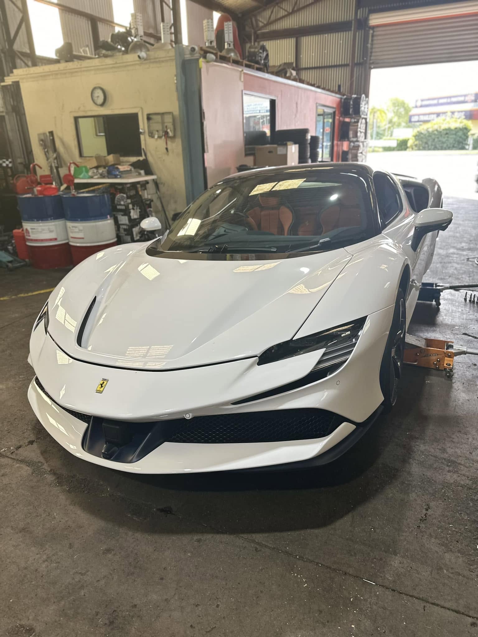 A white sports car inside the Tyre Select workshop.